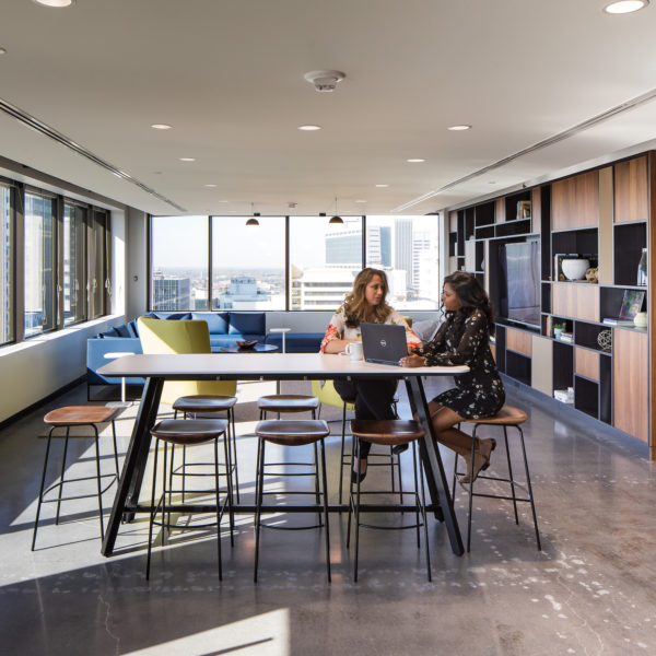 A long table with two employees working in front of a window at 100 Peachtree Street building.