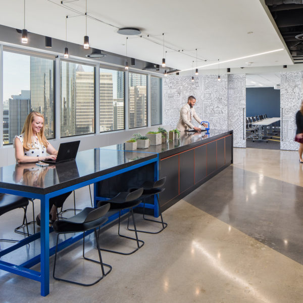 Employees at a table at 100 Peachtree Street with a laptop and windows